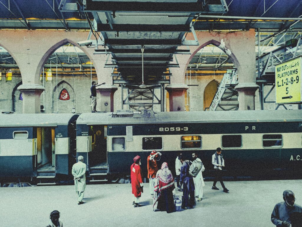 Passengers boarding a train at Lahore Railway Station, showcasing the bustling environment and architectural design.